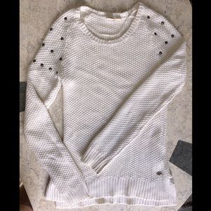 Knitted white sweater with studs application on shoulders.